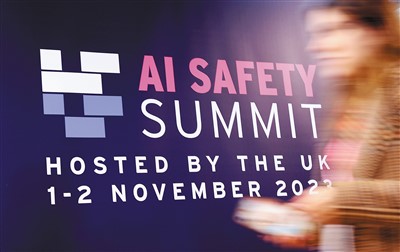 在英國布萊奇利園，一名參會者經過首屆人工智能安全峰會的宣傳展板。 新華社記者 李 穎攝