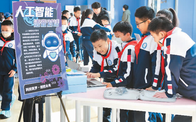 3月26日，在山東省青島市市北區同安路小學啟動的科學教育現場會上，學生們在編寫人工智能語音對話程序。   王海濱攝（人民圖片）