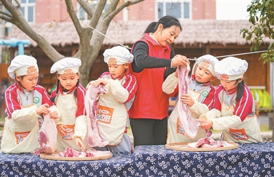 12月4日，浙江省湖州市長興縣泗安鎮二界嶺中心幼兒園開展“迎大雪 藏美味”主題活動，孩子們在泗安鎮雲峰村志願者的指導下體驗腌制臘肉，了解大雪節氣的傳統習俗，感受濃濃的節氣文化。陳海偉攝（人民視覺）