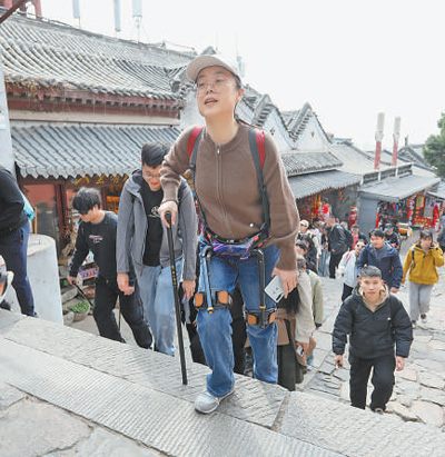 清明假期，游客在泰山景区体验登山智能辅助产品。   陈  阳摄