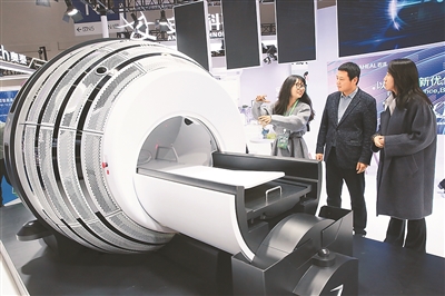 日前，2025中國醫學裝備展覽會在重慶國際博覽中心舉行。圖為觀眾在參觀“放射外科機器人”產品。該機器人是專門針對顱內和頭頸部腫瘤、病變的放射外科系統，也是全球首創完全自屏蔽功能的放療設備。 趙杰昌攝（人民視覺）