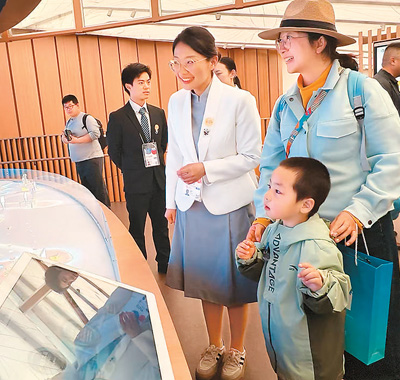 在日本大阪世博會中國館二樓“生生不息”展區，工作人員（左三）向參觀者介紹中國的智慧城市方案。   本報記者 楊俊峰攝