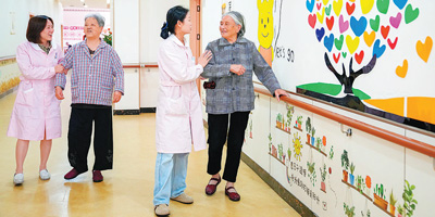 临川区铂金水岸社区居家养老服务中心，医护人员陪老年人做康复训练。