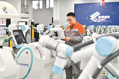 2025年4月1日，在遨博（山东）智能机器人有限公司，工程师在调试护理机器人。    新华社记者 郭绪雷摄