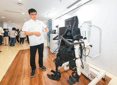 2024年，在上海市嘉定区的上海交通大学医学院附属瑞金医院肿瘤质子中心，工作人员介绍用于恢复患者下肢的医疗机器人。新华社记者 王 翔摄