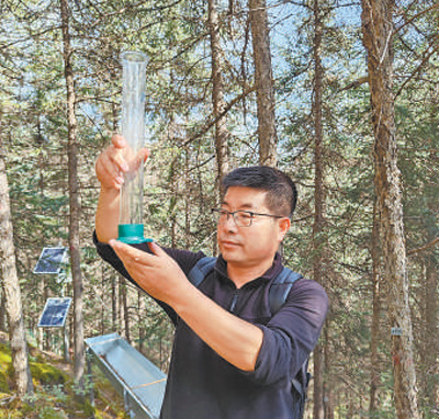 敬文茂在觀測降水情況。 本報記者 宋朝軍攝