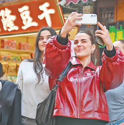 重庆市沙坪坝区磁器口古镇，外国游客正在拍照打卡。 孙凯芳摄（影像中国）