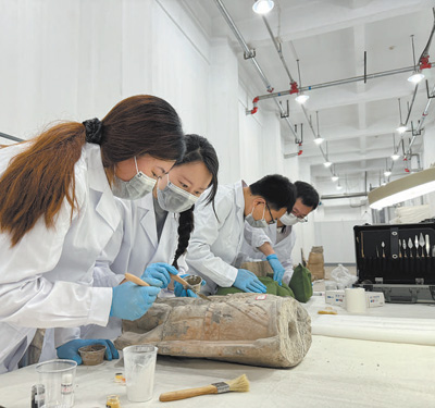 龍門石窟研究院的工作人員在修復石窟文物。     本報記者  張文豪攝