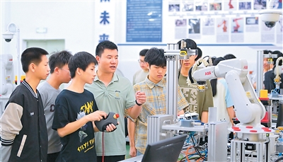 江西省瑞金市瑞金中等專業學校工業機器人實訓基地，老師在指導學生在操作智能機械臂。 新華社發