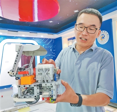 蒋际君在展示学生设计制作的机器人。   王 琨摄