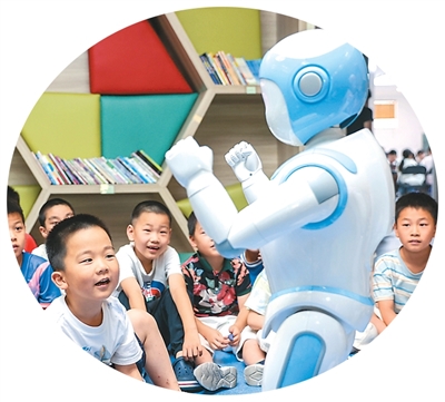 7月9日，浙江省湖州市德清县阜溪街道社区教育中心爱心托管班，小朋友与机器人互动。   姚海翔摄 （人民图片）