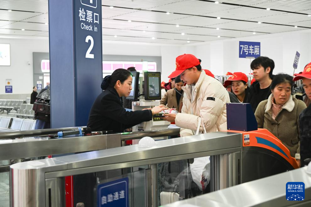 2月22日，來自黔東南州各區縣的外出務工人員及家屬在凱裡南站檢票進站。新華社發（邵健攝）