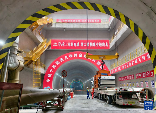 6月20日，中铁十四局建设工人在浙江省甬舟铁路金塘海底隧道项目宁波侧协同吊装管片。  新华社发（胡学军 摄）