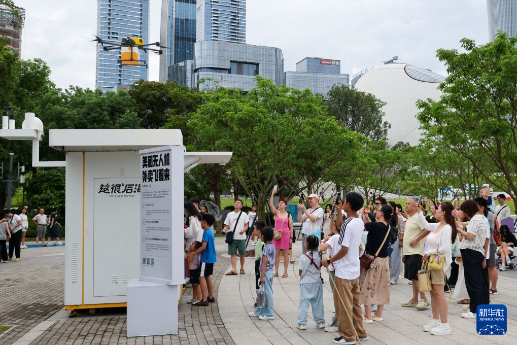 中外游客在深圳人才公园观看美团无人机送外卖。新华社记者 梁旭 8月3日摄
