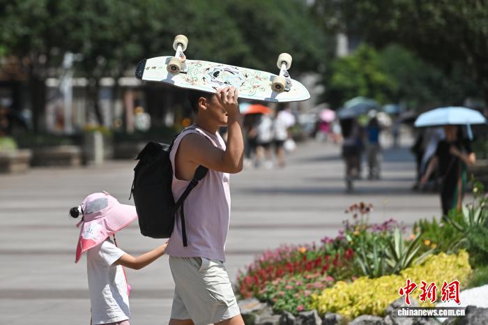 资料图：7月14日，重庆观音桥步行街，市民冒着高温出行。中新社记者 何蓬磊 摄