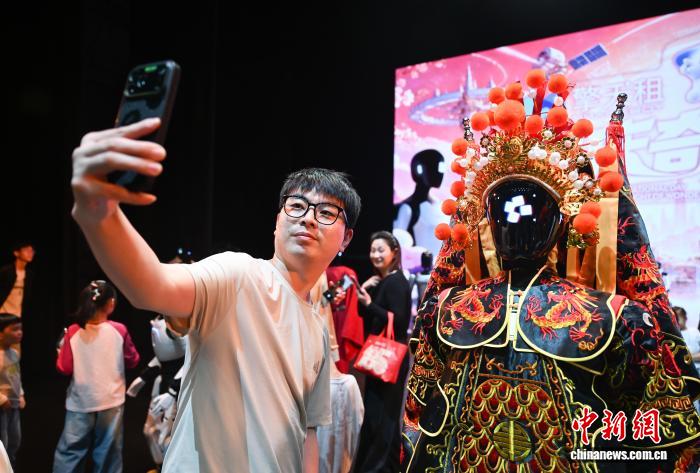 觀眾和人形機器人合影。中新社記者 王剛 攝