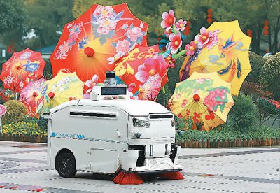 2月2日，在浙江省義烏市繡湖廣場，一輛白色無人駕駛環衛機器人在清掃路面。龔獻明攝（人民圖片）