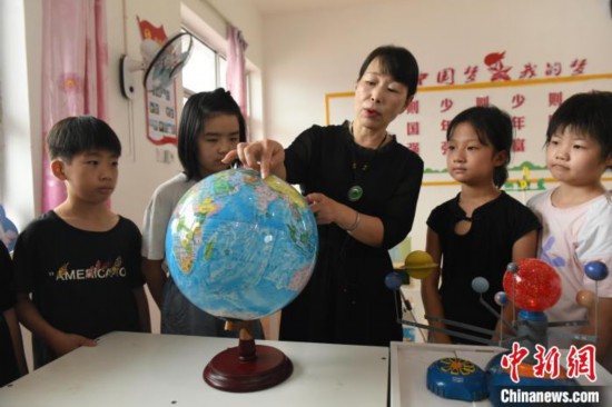 圖為河北省深州市兵曹鄉兵曹完全小學,航天員蔡旭哲的姐姐蔡旭娜(中)為學生們講解航天知識。袁佳凱 攝