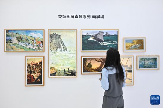 9月13日，一名參觀者在京東方展台觀看類紙畫屏直顯系列畫屏牆，該屏幕運用無損Gamma專利顯示技術、低反防炫光技術、自適應感光技術等多種技術實現類紙顯示效果。新華社記者 李鑫 攝