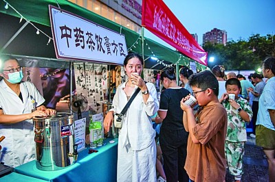 在安徽蕪湖一中醫藥文化夜市上，市民品嘗中藥茶飲。肖本祥攝/光明圖片