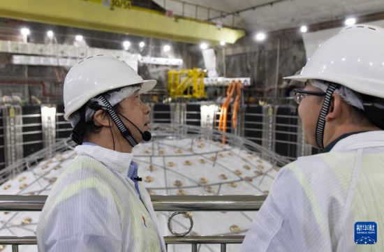 10月10日，江門中微子實驗首席科學家、項目經理王貽芳院士（左）和同事在實驗大廳交流建設進展情況。新華社記者 金立旺 攝