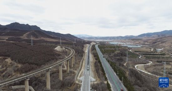 11月21日，全线在内蒙古赤峰市克什克腾旗，电气一列由电力机车牵引的化开货运列车行驶在内蒙古集通铁路天合永特大桥上（无人机照片）。新华社记者 贝赫 摄