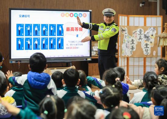 12月2日，在南京市雨花台區普德村幼兒園，交警向小朋友演示交通指揮手勢。新華社發（蘇陽攝）