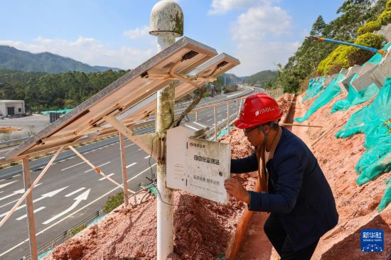 12月4日，中鐵十一局管理人員在黃茅海跨海通道台山段路基邊坡檢查北斗衛星智能高邊坡監測儀，該設備可實時監測邊坡位移。新華社記者 劉大偉 攝