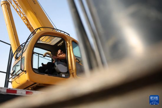 一位吊車司機在中鐵二十局承建的甘肅臨夏綜合物流園項目建設現場進行起吊作業（1月6日攝）。新華社記者 陳斌 攝