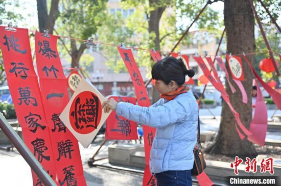 资料图：图为市民将春联、福贴挂起晾干。中新社记者 陈楚红 摄