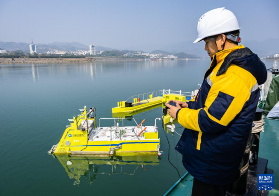 2月25日，技术人员操控智能清洁机器人在三峡大坝坝前水域收集水上漂浮物。新华社发（郑家裕摄）