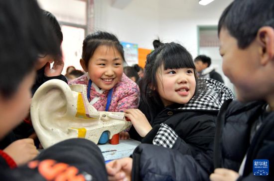 3月3日，在河南省商丘市夏邑县育才学校，小学生在一起交流如何爱耳护耳。新华社发（苗育才摄）