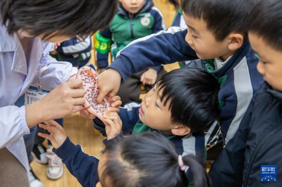 3月3日，医护人员为江苏省南京市雨花台实验幼儿园善水湾分园的小朋友讲解耳朵的穴位和功能。新华社发（张梦摄）