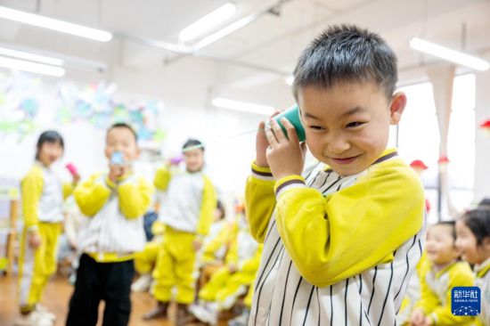 3月3日，浙江省湖州市长兴县龙山幼儿园，孩子们利用自制的传声筒听取声音。新华社发（谭云俸摄）