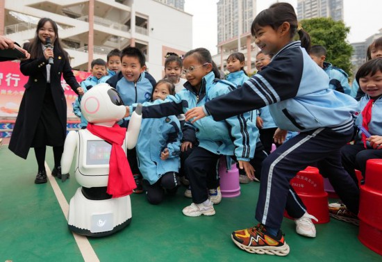 2025年2月17日，广西南宁市邕宁区龙岗北小学的学生与AI智能机器人亲密互动。新华社发（马华斌摄）