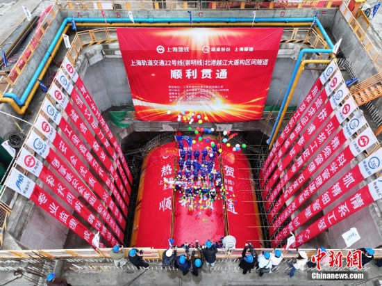 图为建设者挥舞旗帜庆祝隧道贯通。（无人机照片）中新社记者 张亨伟 摄