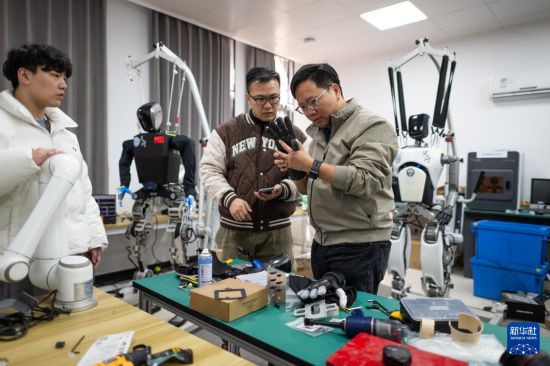 3月19日，在武漢大學機器人學習算法與軟操作實驗室內，研發團隊在對“天問”人形機器人進行研發調試。 新華社記者 肖藝九 攝