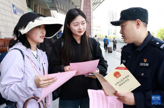 4月13日，武漢鐵路公安局民警在湖北省武昌站為游客講解國家安全知識。新華社發（趙軍攝）