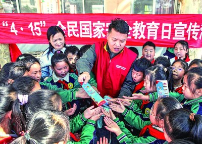 在河南省焦作市博愛縣清化鎮街道七街小學，志願者向學生宣傳國家安全知識。新華社發