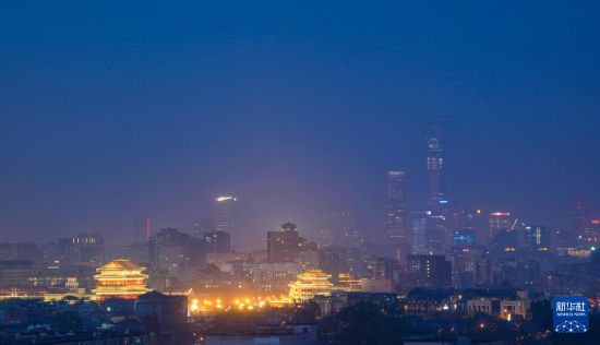 北京日落后的正陽門城樓、箭樓和遠處的CBD建筑群（4月14日攝）。新華社記者 陳曄華 攝