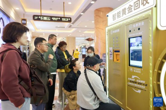 5月5日，在上海市普陀区一家商场内的“智慧金店”，人们观看黄金回收设备运行情况。新华社记者 王翔 摄