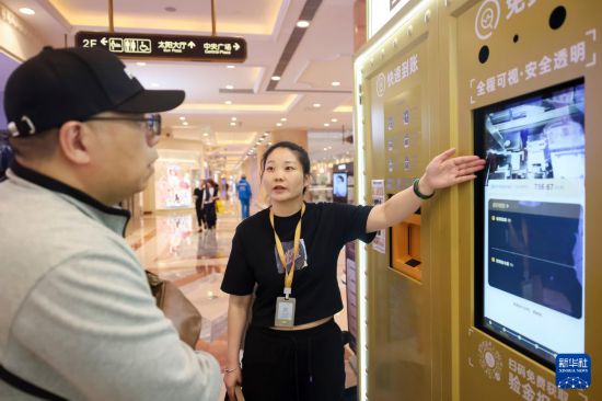 5月5日，在上海市普陀区一家商场内的“智慧金店”，工作人员向用户介绍黄金回收过程。新华社记者 王翔 摄