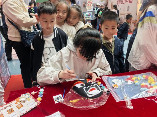 在“八零东方韵”主题展区“千面丹青”活动中，小朋友们正在亲手绘制脸谱。（青海省科技馆供图）