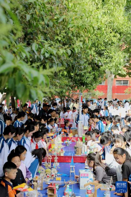 5月7日，在河南省濟源市軹城鎮校園科技節活動上，同學們在參觀科技小制作。新華社發（段二平攝）