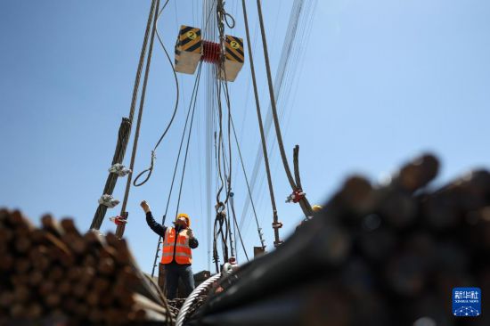 5月10日，中鐵二十局的建設者在蘭永臨高速公路洮河大橋施工現場進行纜索吊裝系統試吊作業。新華社記者 陳斌 攝