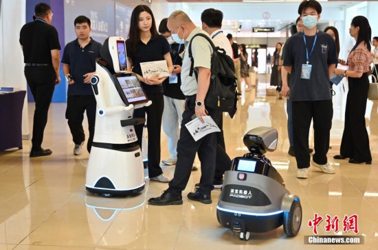 图为一展位展出的服务机器人吸引嘉宾咨询。中新社记者 陈楚红 摄