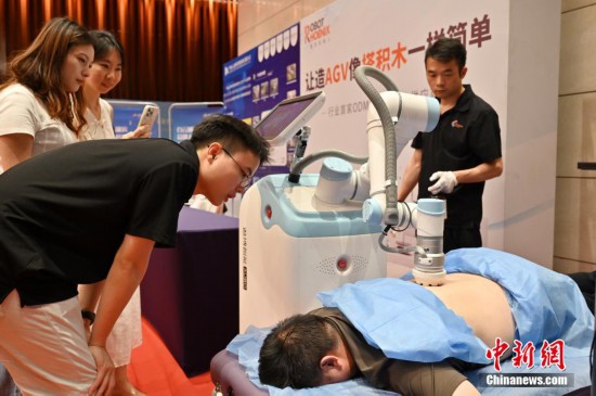 图为按摩机器人吸引参观者体验。中新社记者 陈楚红 摄