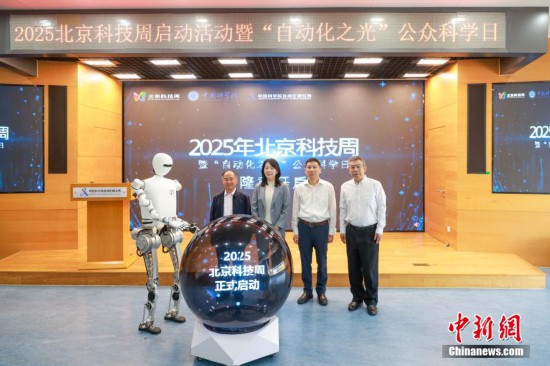 圖為人形機器人與嘉賓共同啟動北京科技周。中新社記者 賈天勇 攝