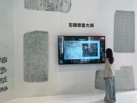 5月24日，在第二十一届文博会上，观众体验用数字技术修复石碑文字。新华社记者 陈宇轩 摄