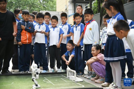 5月26日，在西安市新城區華山實驗小學，學生在老師的指導下體驗機器人足球。新華社記者 張博文 攝